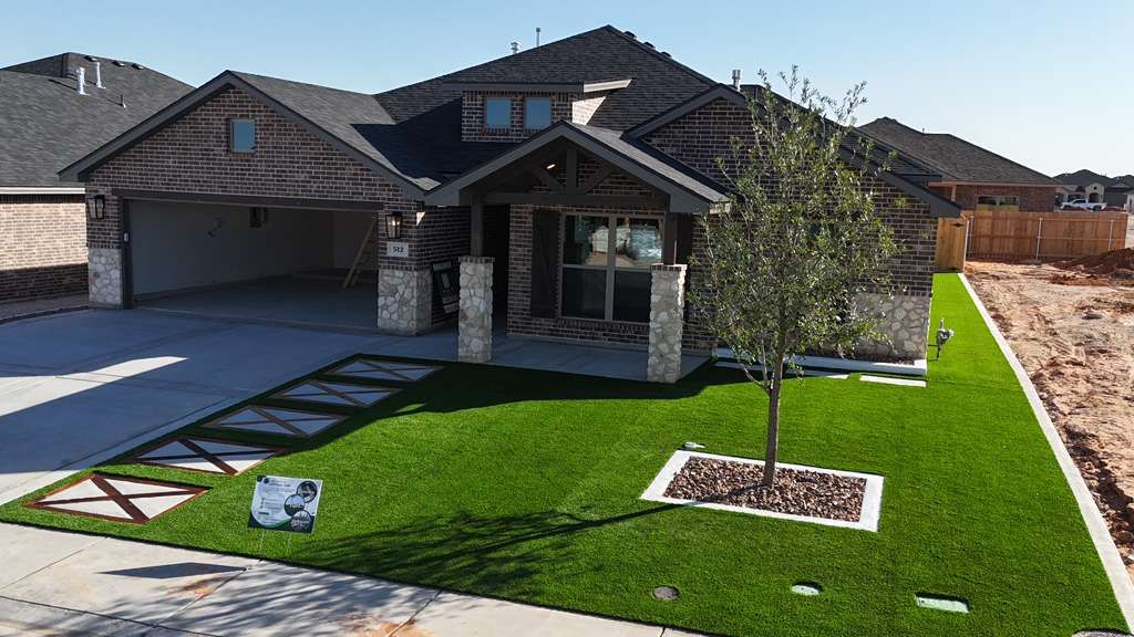Front-yard artificial turf with paver walkway and scored stained-concrete inlays in Deer Meadows, Odessa TX