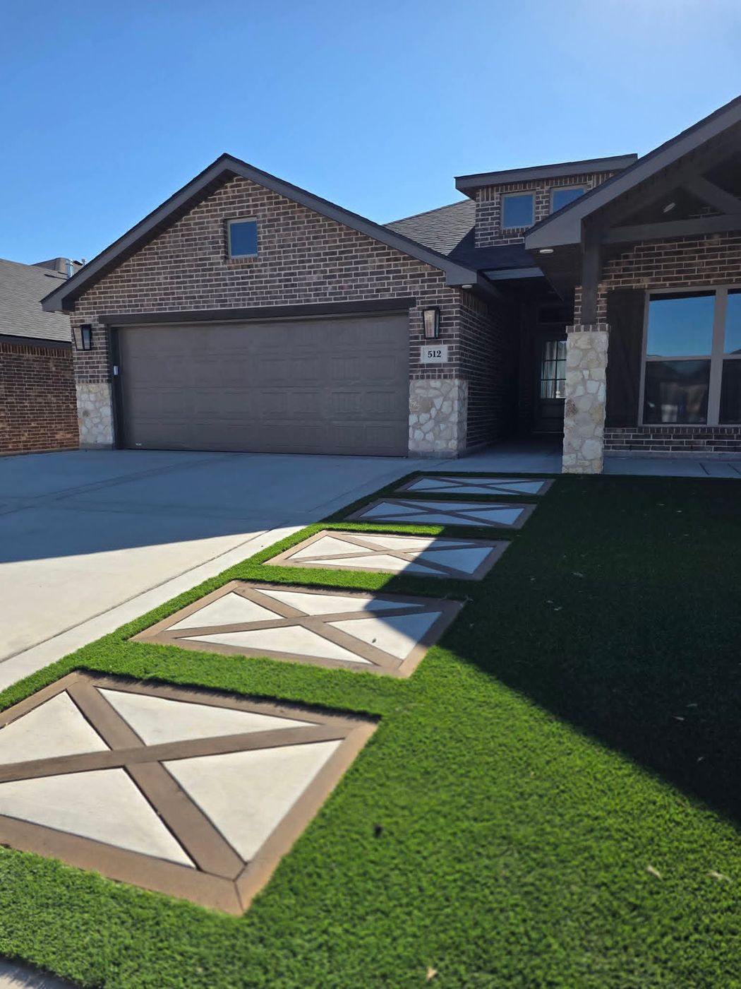 Front entry walkway with diamond-scored stained stepping pads set in artificial turf in Deer Meadows, Odessa TX
