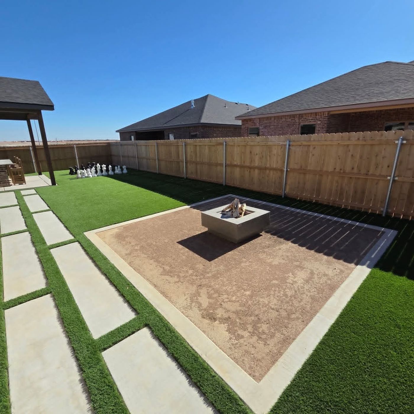 Backyard turf lawn with paver walkway, fire-pit court and giant lawn chess in Deer Meadows, Odessa TX