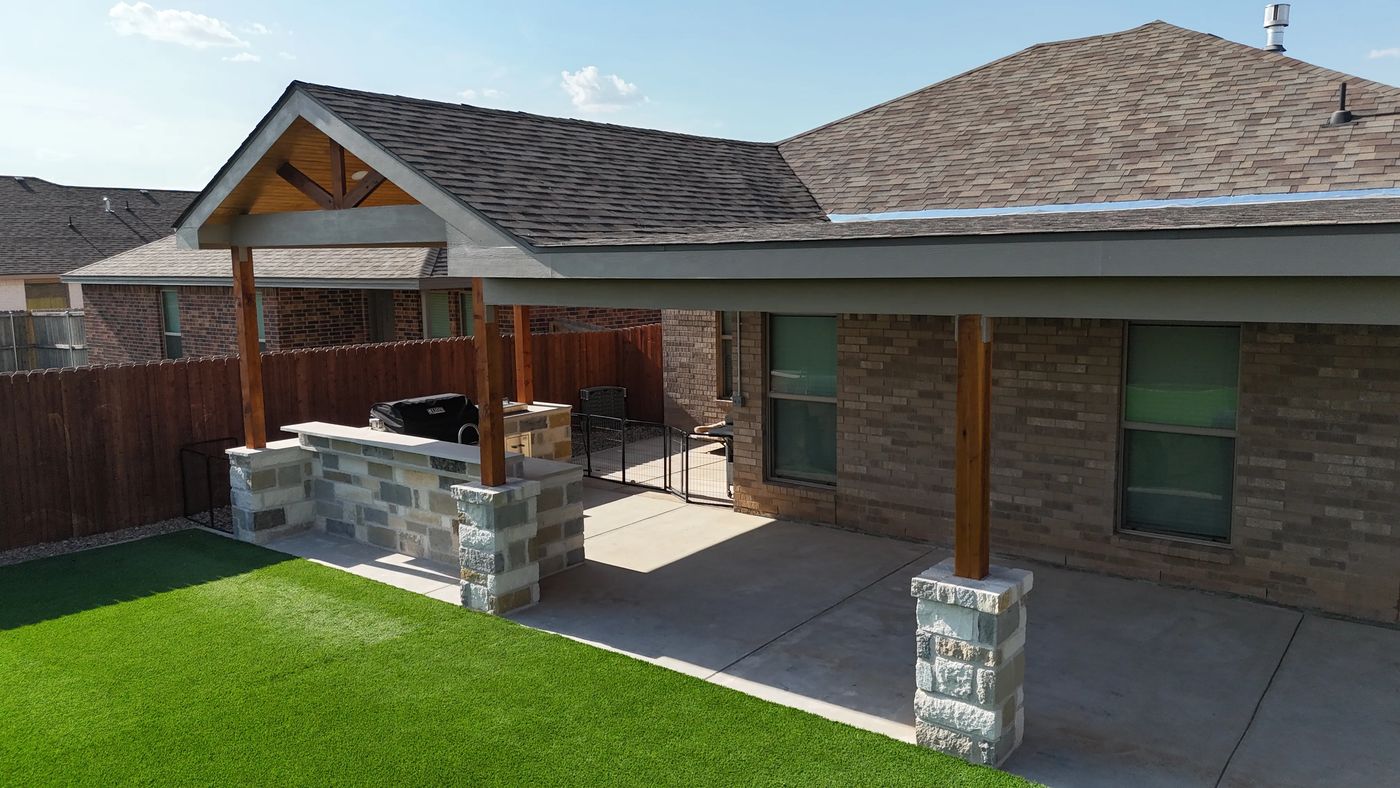 Gable covered patio with stone column bases and stone-base outdoor kitchen in Desert Ridge, Odessa TX