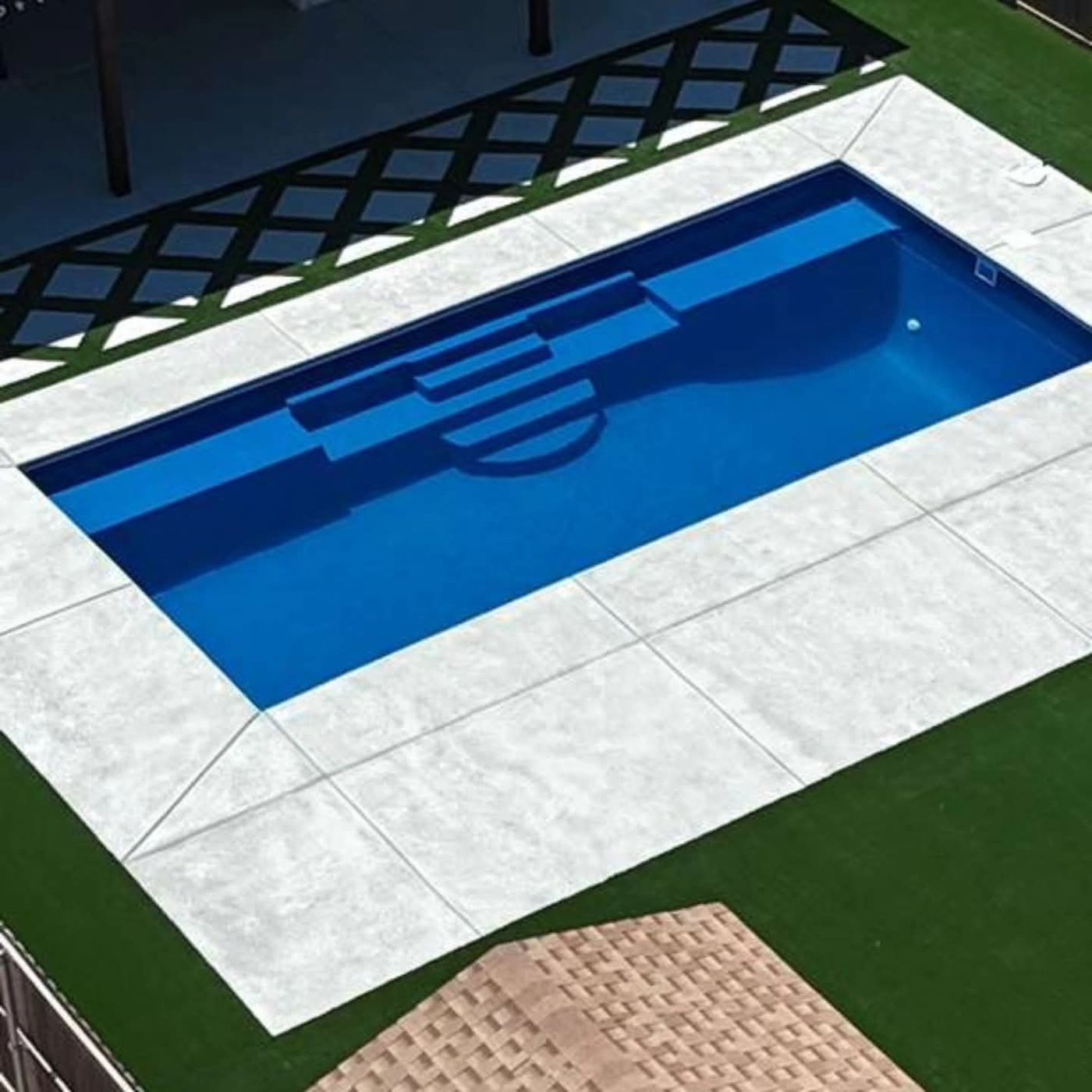 Aerial of fiberglass pool with decorative concrete deck, turf and steel pergola in Homestead at Parks Bell Ranch, Odessa TX