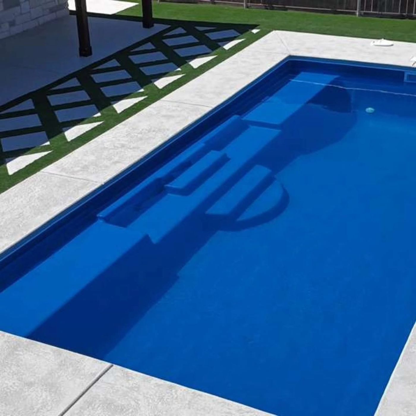 Fiberglass pool with tanning ledge, stamped-concrete deck and black steel pergola in Homestead at Parks Bell Ranch, Odessa TX