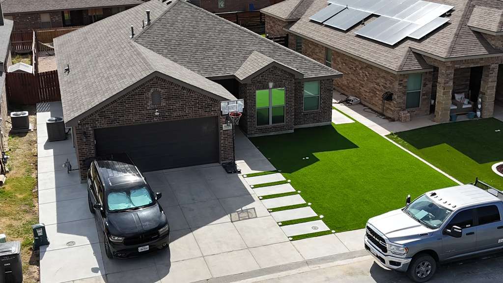 Front-yard artificial turf with large-format concrete paver steppers in Lone Star Trails, Midland TX