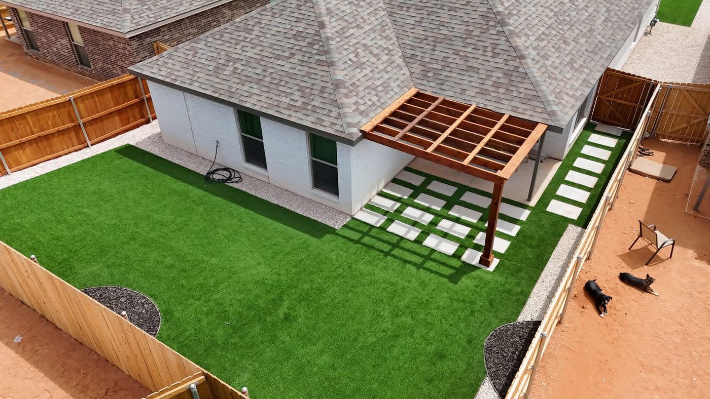 Aerial of artificial turf backyard with cedar pergola and large-format paver grid in Mockingbird Ridge, Midland TX