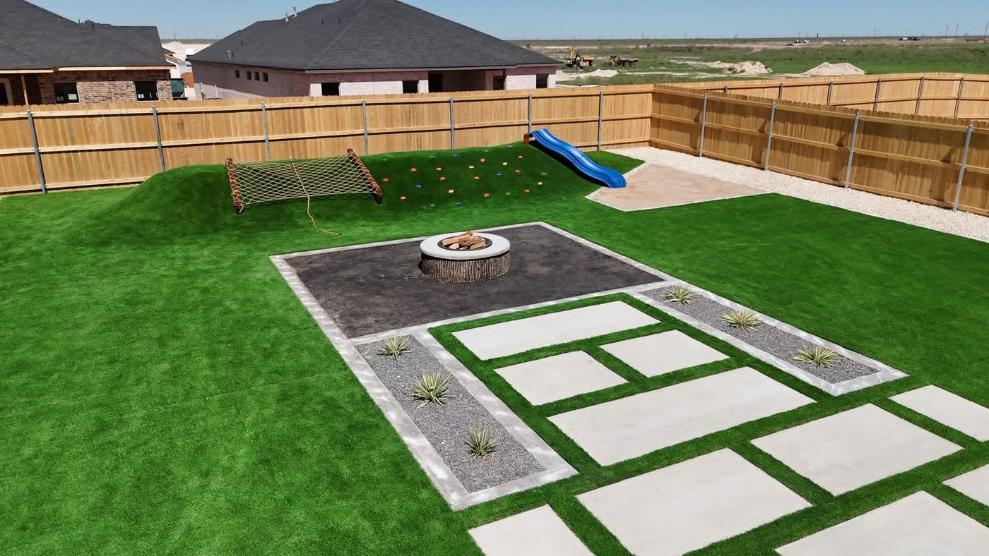 Aerial of family backyard with artificial turf, round fire pit and built-in play zone in Northwest Passage, Midland TX