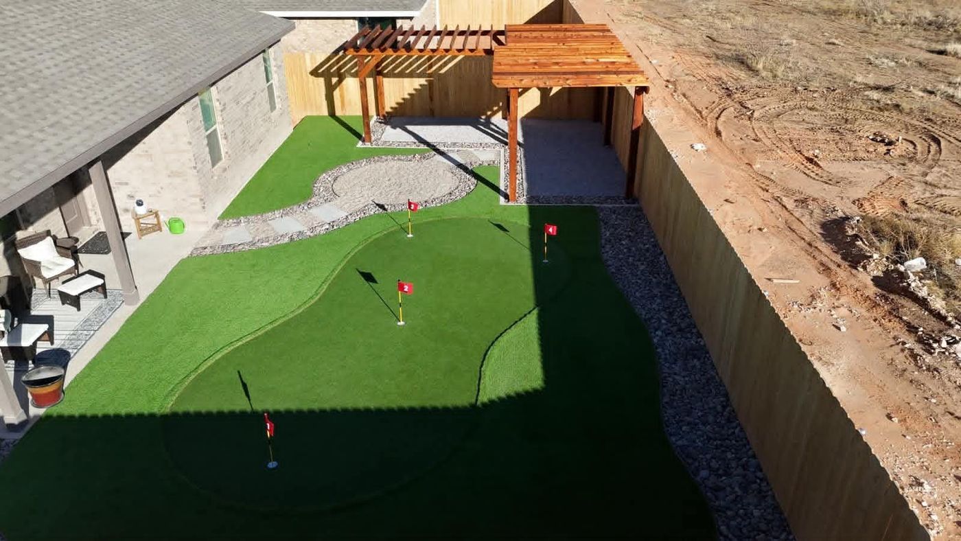 Backyard putting green with flags, cedar pergola and covered pavilion in Northwest Passage, Midland TX